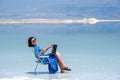 Woman freelancer works at a laptop on the shores of the dead sea in israel Royalty Free Stock Photo