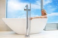 woman in freestanding white bath. Modern bathroom interior design. Beauty, healthy lifestyle concept Royalty Free Stock Photo