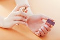 Woman with french ombre manicure applies perfume on her wrist. Scincare. Cosmetics