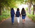 Woman, friends and holding hands with backpack in park to school for unity, teamwork or community. Rear view of young Royalty Free Stock Photo