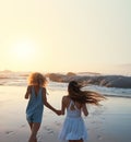 woman friends running on beach at sunset holding hands having fun summer vacation enjoying freedom Royalty Free Stock Photo