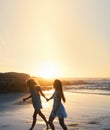 woman friends running on beach at sunset holding hands having fun summer vacation enjoying freedom Royalty Free Stock Photo