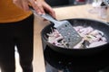 Woman fries onions in skillet in kitchen closeup