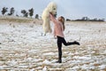 Woman frolicking in the snow with teddy bear Royalty Free Stock Photo