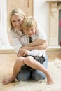 Woman in front hallway hugging young boy and smili