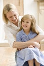 Woman in front hallway hugging young girl and smil