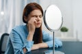 woman in front of the mirror cosmetics dermatology makeup skin care