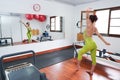 woman in front of the mirror looking while streching in a pilates room