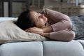 Woman frowning lying on sofa suffer from daytime restless sleep