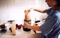 Woman, fruit and smoothie in kitchen with blender for healthy breakfast, morning routine and body detox. Person, meal