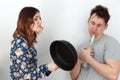 Woman with frying pan scolding alcoholic husband