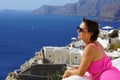 Woman with Fuchsia dress admires the Oia Scenery in Santorini