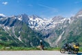 Woman in full biker outfit, copy space. Touring motorcycle with big bags. The snowy peaks of the Johannisberg and Hohe Dock