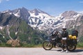 Woman in full biker outfit, copy space. Touring motorcycle with big bags. The snowy peaks of the Sonnenwelleck and Hohe Dock