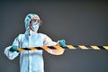 Woman in a full protective suit secures with a barrier tape Royalty Free Stock Photo