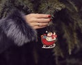 Woman in a fur coat decorating a Christmas tree