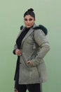 a woman in a fur hat with long green coat and black pants Royalty Free Stock Photo