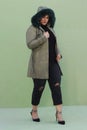 a woman in a fur hat with long green coat and black pants Royalty Free Stock Photo