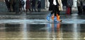 Woman with gaiters at high tide in Venice