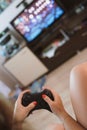 Woman with gamepad plays video games