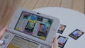 Woman gamer using game console Nintendo 3ds with AR app - close up view
