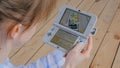 Woman gamer using game console Nintendo 3ds with AR app