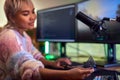 Woman Gaming At Home Making In Game Purchase With Credit Card Sitting At Desk With Multiple Monitors