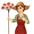 Woman with garden hat holding rake