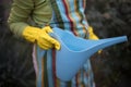 Woman in garden holding can.