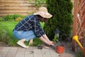 woman gardener in hat working in the garden in the backyard Royalty Free Stock Photo