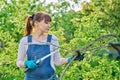 Woman gardener with saw and dry cut branches in garden Royalty Free Stock Photo