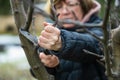 Woman gardener using garden saw on to cut dry tree branches. Spring pruning of trees and bushes in garden Royalty Free Stock Photo