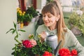 Woman Gardener Watering Plants at City Balcony