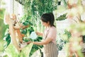 Young woman plant owner shop watering plants in a plant shop. Royalty Free Stock Photo