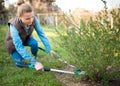 Woman gardener working in the spring garden and trimming branches