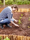 Woman, gardening and plant in backyard soil, dirt or growing vegetables. Person, planting or harvest of plants in ground