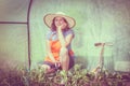 Woman with gardening tool working in greenhouse