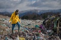 Woman with gas mask walking on landfill, environmental concept. Royalty Free Stock Photo