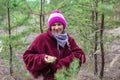 Woman gathers mushrooms among the pines