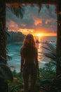 A woman stands by the ocean at sunset, gazing at the colorful sky and water Royalty Free Stock Photo