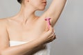 Woman gently shaving armpit epilation hair removal with ergonomic pink shaver. Body care skin care beauty concept. Royalty Free Stock Photo