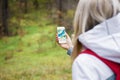 Woman geocaching in forest and using map app on smartphone Royalty Free Stock Photo