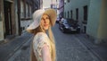 Woman gesturing follow me on street. Smiling young lady looking at camera and gesturing follow me on street. Royalty Free Stock Photo