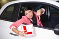 Woman gesturing thumbs down holding a learner driver sign Royalty Free Stock Photo