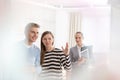 Woman gesturing to smiling man while saleswoman standing in apartment