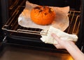 Woman gets baked pumpkin out of the oven