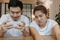 Woman gets bored boyfriend addicted mobile game on their date. Asian couple