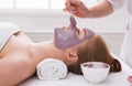 Woman gets face mask by beautician at spa Royalty Free Stock Photo