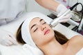 Woman getting beauty treatment in medical spa center. Skin care and rejuvenation concept. Beautician holding apparatus near the Royalty Free Stock Photo