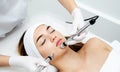 Woman getting beauty treatment in medical spa center. Skin care and rejuvenation concept. Beautician holding apparatus near the Royalty Free Stock Photo